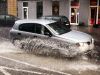 Samochód przejeżdża przez kałużę w centrum Warszawy